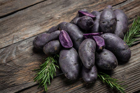 Raw sweet potatoes on wooden background closeup. Batata potato. vegan food ingredient. banner, menu, recipe place for text, top view.の写真素材