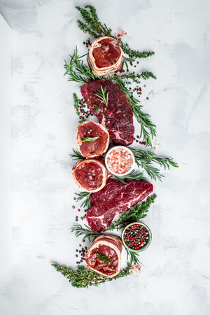 Variety of raw black angus prime meat steaks beef rump steak, Tenderloin fillet mignon for grilling on light background. vertical image. top view. place for text.の写真素材