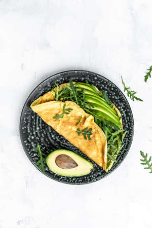 Omelet and Salad with green vegetables avocado and arugula, Delicious vegan, vegetarian breakfast.
