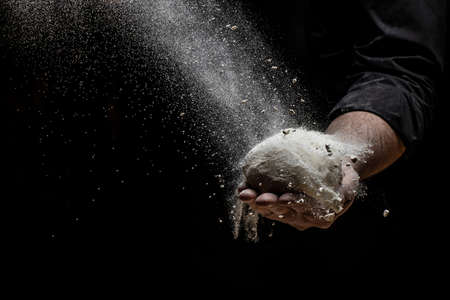 Beautiful and strong men's hands knead the dough from which they will then make bread, pasta or...