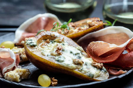 Appetizer with pear baked with blue cheese, nuts and honey, prosciutto. summer snacks. Pear appetizer with jamon, Long banner format. top viewの写真素材