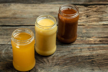 Collection of jars of different types of honey, light, dark and cream, Composition with three jars...