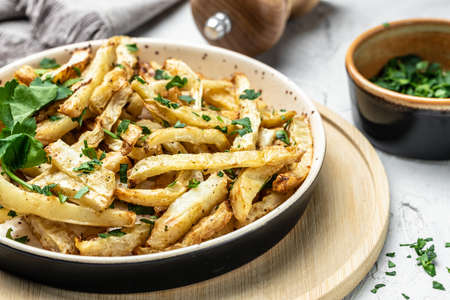 Roasted Parsnips on light Background. side dish on plate. Delicious vegetarian breakfast or snack,...