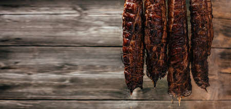 Smoked ham in homemade smokehouse. Natural product from an organic farm, produced by traditional methods. Long banner format.の写真素材