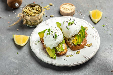 Sandwiches with avocado Poached Eggs. sliced avocado and egg on toasted bread for healthy breakfast...