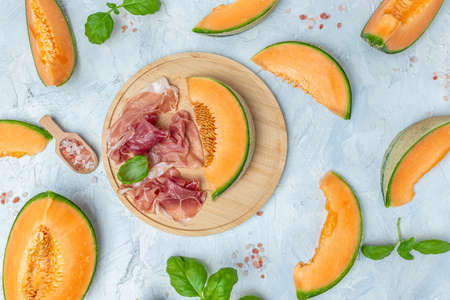 Cantaloupe melon with ham prosciutto jamon. Traditional Spanish and Italian appetizer. banner, menu, recipe top view.の写真素材