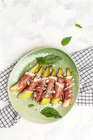 Appetizer with pear, blue cheese and prosciutto ham, Healthy fats, clean eating for weight loss, Restaurant menu, dieting, cookbook recipe vertical image. top view. place for text.の写真素材