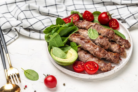 chevapchichi or Kofta kebab, Bacon wrapped minced meat with spinach, avocado and cherry tomato, Healthy fats, clean eating for weight loss. Keto paleo diet menu, top view,の写真素材