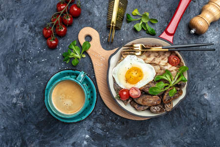 Baked sweet purple potatoes, grilled bacon and fried egg in pan and coffee on white background. Keto breakfast or lunch. Healthy fats, clean eating for weight loss, top view,の写真素材