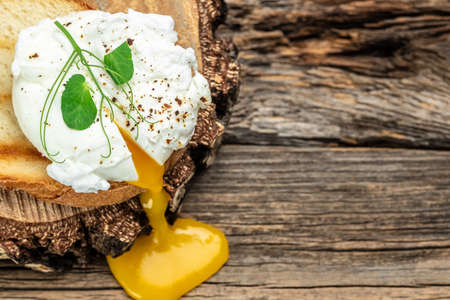 Poached egg on toast on the wooden table, Healthy food, keto diet, diet lunch concept. top view.