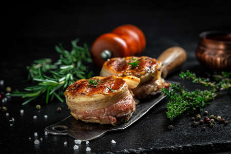 Premium Beef Steak. portion of juicy beef tenderloin steak covered bacon on dark concrete background with spices. Ketogenic diet food, top view,の写真素材