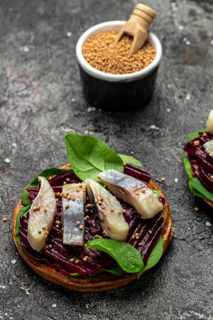 sandwich with slices of Atlantic herring fillet, beetroot salad, green spinach, onion, Scandinavian...