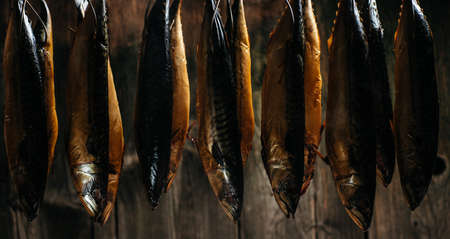 Smoked fish mackerel or scomber in smokehouse. Smoking Process Fish. banner, menu, recipe place for...