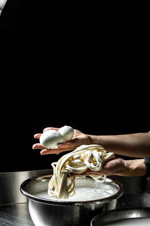 Cheesemaker showing freshly made mozzarella. The homemade cheese maker produces caciocavallo. Pasta...