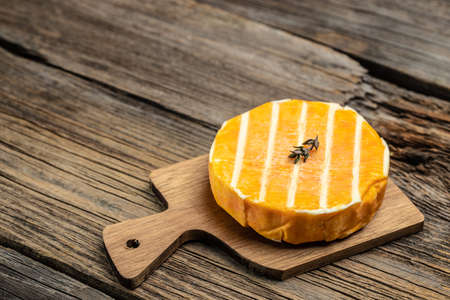 cream Round brie or camembert cheese on a wooden board. Rougette cheese on a wooden background, banner, menu, recipe place for text, top view.の写真素材