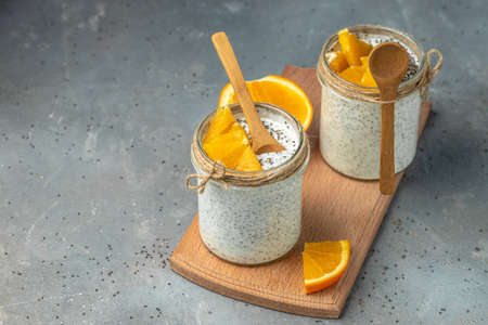 Chia Seed with lactose-free yogurt in glass decorated with citrus fruit. Yogurt with chia seeds on gray background. healthy superfood. Health food. place for text.の写真素材