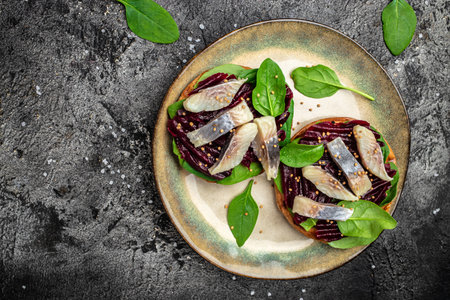 Herring fillet. sandwich with slices of pickled Atlantic herring fillet, beetroot salad, green spinach, onion, Scandinavian cuisine. banner, menu, recipe place for text, top view.の写真素材