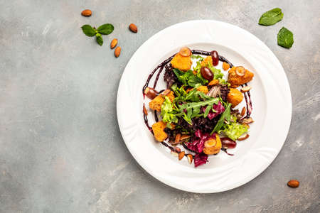 Salad Camembert cheese baked served on lettuce with vegetables, almonds and berry sauce. banner, menu, recipe place for text, top view.の写真素材