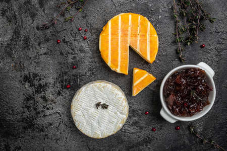 Camembert, Brie, Gorgonzola and blue cream cheese with thyme and onion marmalade jam. french cuisine. An aperitif on a dark background. place for text, top view .の写真素材