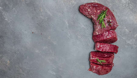 Beef Tenderloin fillet with rosemary and spices. Preparing fresh beef steak ready to cook, Long banner format. Restaurant menu, dieting, cookbook recipe. place for text. top view.の写真素材