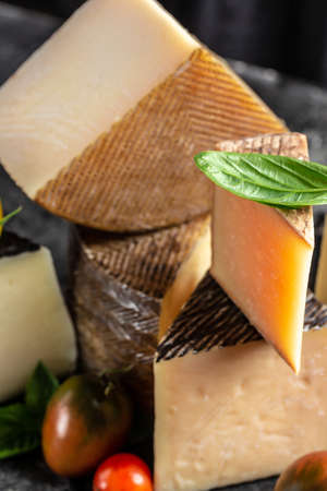 Cheese board of various types of soft and hard cheese. spanish manchego cheese, international dairy delicacies. vertical image.の写真素材