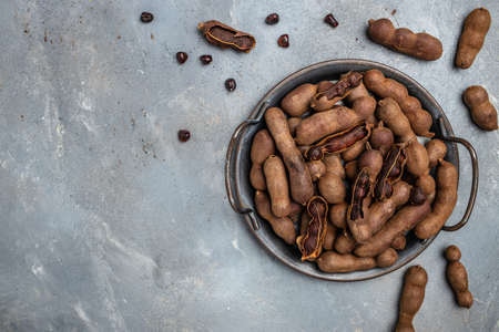 Delicious ripe tamarinds on a metal tray on a gray background, banner, menu, recipe place for text, top view,の写真素材