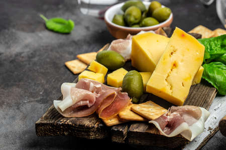 Antipasto board Platter with Spanish ham jamon serrano or Italian prosciutto crudo, Italian hard cheese pecorino toscano on a dark background.の写真素材