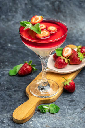 Panna cotta vanilla with strawberry sauce jelly and mint. Italian dessert, vertical image.の写真素材