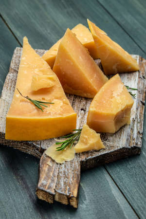 Parmesan cheese on a wooden background. Traditional Italian cheese.