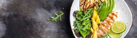 Buddha bowl, Grilled chicken breast, halloumi, pineapple, avocado, green rocket salad, lime and olive oil. healthy and balanced food. Long banner format. top view.の写真素材