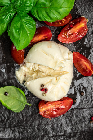 fresh soft white burrata cheese ball made from mozzarella and cream from Apulia, Italian Mediterranean cuisine, vertical image. top view. place for text.の写真素材