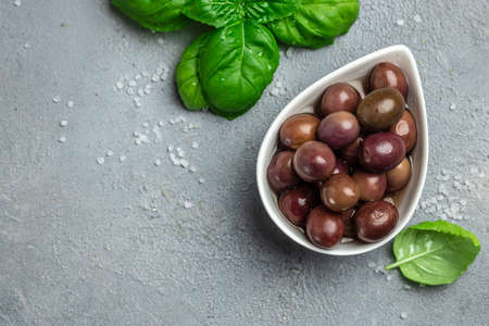 pink olives with fresh rosemary in a small bowl on gray background. Long banner format. top view.の写真素材