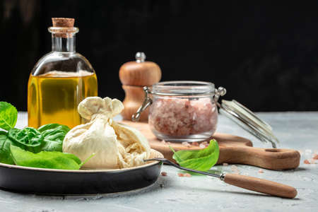 fresh handmade soft Italian cheese from Puglia, white balls of burrata or burratina cheese Basil and Olive Oil and Ciabatta. place for text, top view.の写真素材