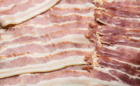 Close up Bacon slices and rosemary on a wooden board, Keto diet food ingredients. Long banner...