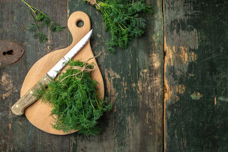 Chopped fresh dill on a cutting Board and a bunch of dill preparation for serving freezing size...