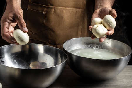 The homemade cheese maker produces handmade mozzarella with fresh bio milk. process of making mozzarella. Italian hard cheese silano or caciocavallo in cheesemaker hands.の写真素材