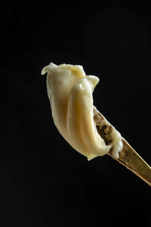 cream cheese and butter for breakfast. melted cheese on dark background. vertical image. place for...