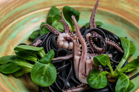 Squid ink spaghetti with seafood octopus, mussels and shrimps on dark background. Restaurant menu, dieting, cookbook Food recipe background. close up top view,の写真素材