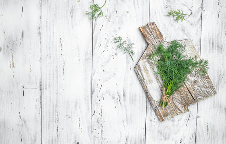 Organic fresh dill with roots on wooden light background. Healthy and Benefit of Dill. Detox and healthy superfoods. place for text, top view.の写真素材