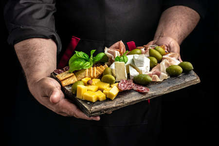 Antipasto board Platter with Spanish ham jamon serrano or Italian prosciutto crudo, Italian hard cheese pecorino toscano on a dark background. aperitivo party.の写真素材