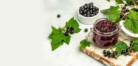 Jar of delicious homemade black currant curd, custard or jam and fresh berries on white concrete background. Long banner format. top view.の写真素材