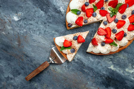 piece of tasty cake pie tart with fresh strawberries, raspberries, blueberry with shovel. Restaurant menu, dieting, cookbook recipe top view.の写真素材
