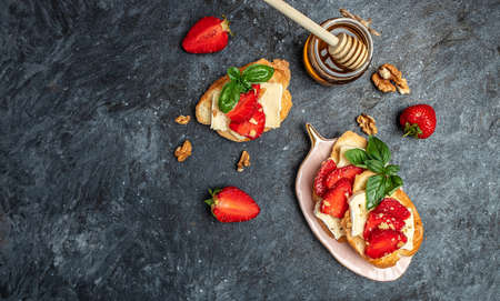 Bruschetta Sandwich with sstrawberries, cheese camembert nuts and honey basil, served as an appetizer.の写真素材
