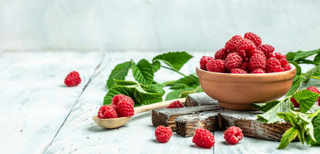 Red raspberries in bowl on white wooden background. Organic Raspberries. redberry. Long banner format. place for text.の写真素材