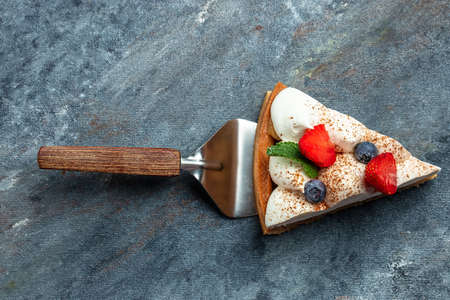 piece of tasty cake pie tart with fresh strawberries, raspberries, blueberry with shovel. Restaurant menu, dieting, cookbook recipe top view.の写真素材