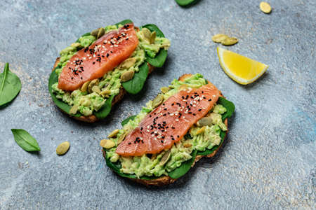 Two toasts whole grain bread with avocado paste and salmon. keto paleo diet. Restaurant menu, dieting, cookbook recipe top view.の写真素材