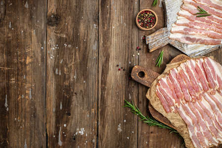 Smoked bacon strips meat slice thin slicing pork fat meal on a wooden background, ketogenic diet, place for text, top view,の写真素材