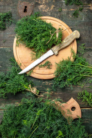 Chopped fresh dill on a cutting Board and a bunch of dill preparation for serving freezing size organic healthy ething natural product portion on a wooden table. top view,の写真素材