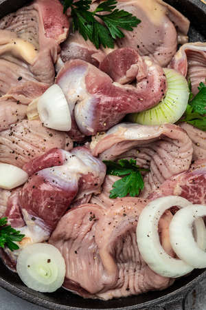Raw uncooked chicken gizzards, stomach on a wooden background. Traditional Korean spicy chicken meat. Food recipe background. close up.の写真素材