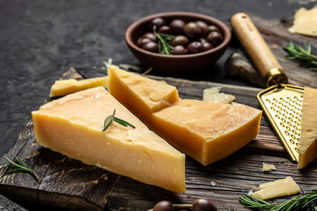 Sliced and grated parmesan cheese with rosemary on a gray table, banner, menu, recipe place for text, top view.の写真素材